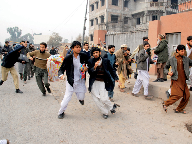 Police resorts to force to scatter demonstrators outside the Peshawar Press Club. PHOTO: GHAFFAR BAIG/EXPRESS