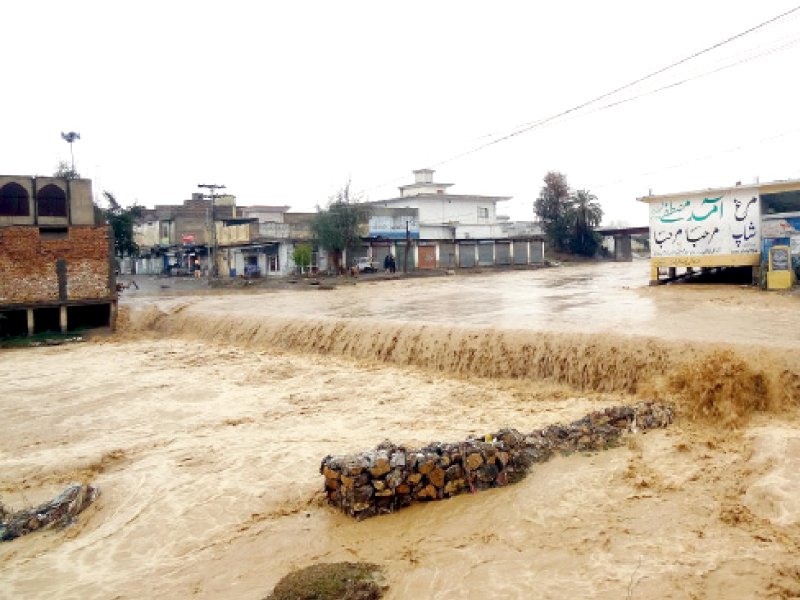 A drain overflows after heavy rains caused flooding in Haripur. PHOTO: INP