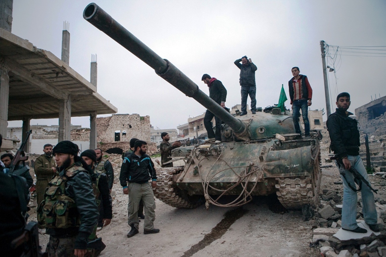 A file photo of Syrian rebels gather around a T-72 tank, captured from government forces. PHOTO: AFP
