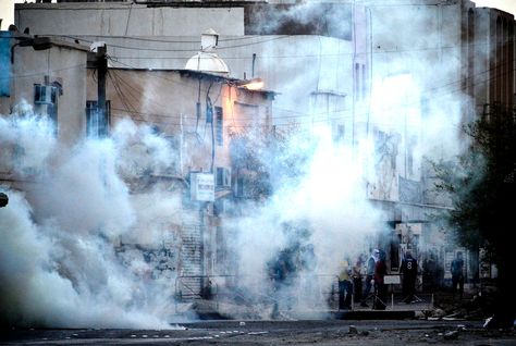 Smoke from tear gas grenades cover Bahraini Shia Muslim youths standing at a makeshift barricade. PHOTO: AFP/FILE