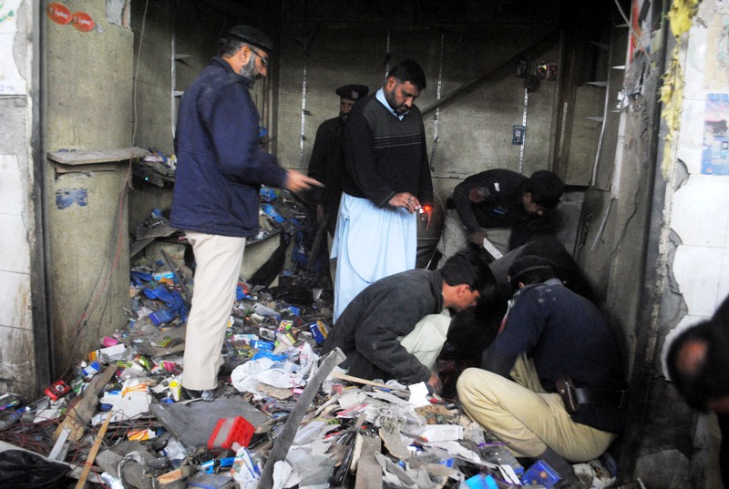 Police carry out investigations after a bomb blast in Peshawar. PHOTO: Muhammad Iqbal/Express
