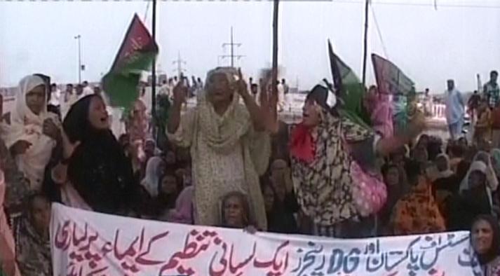 A screengrab shows women holding banners and protesting against the death of the three Lyari residents. SCREENGRAB: EXPRESS NEWS