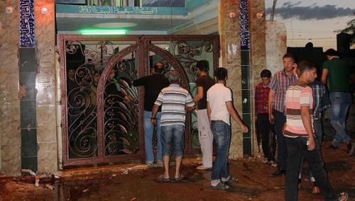 People gather outside alZahraa husseiniyah, a Shiite place of worship, after a suicide bomb attack in the northern Iraq city of Kirkuk on May 16, 2013. PHOTO: AFP