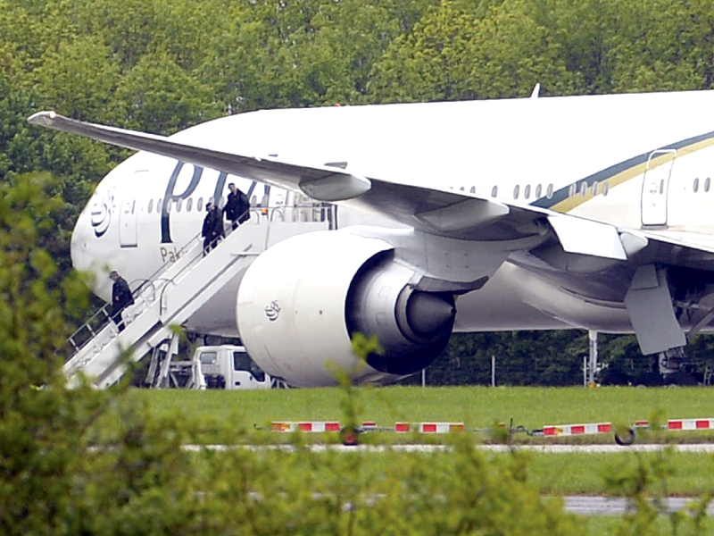 Essex Police officers leave the PIA Boeing 777 aircraft on the tarmac at Stansted Airport. PHOTO: REUTERS