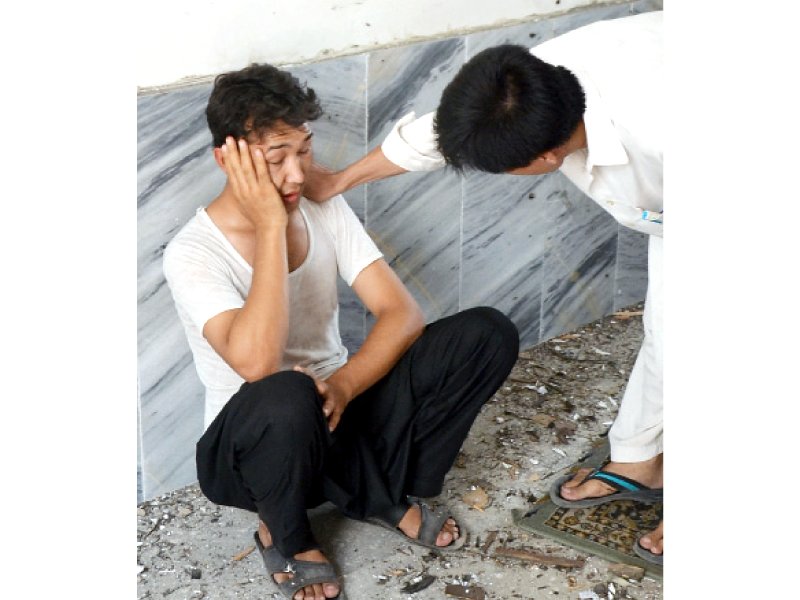 A  bereaved relative mourns the loss of his loved ones following the blast at Hussania Madrassah. PHOTO: SAMEER RAZIQ/EXPRESS