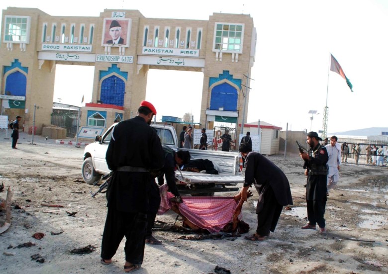 Pakistani security personnel remove the body of a blast victim after a bomb explosion at the border town of Chaman on July 11, 2013. PHOTO: AFP/FILE
