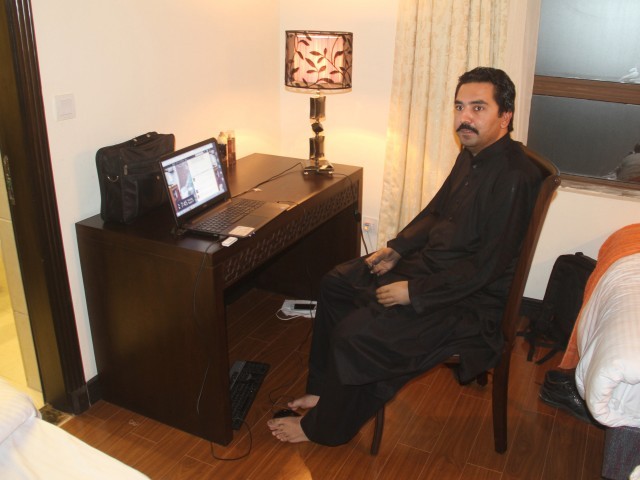 Ansar Abbas uses his computer with his feet after losing his arms in a tragic suicide attack. PHOTO: SHIRAZ HASSAN