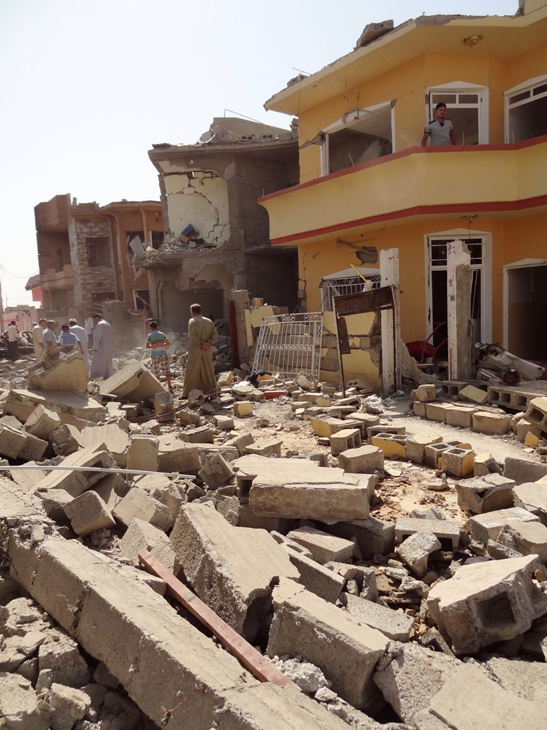 Iraqis inspect the remains of houses after a suicide bomber detonated the day before an explosives-rigged vehicle on August 11, 2013 in the northern city of Tuz Khurmatu. PHOTO: AFP/MARWAN IBRAHIM