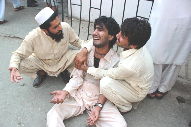 Locals try to console a family member at the hospital after the Qissa Khwani attack. PHOTO: MUHAMMAD IQBAL/EXPRESS