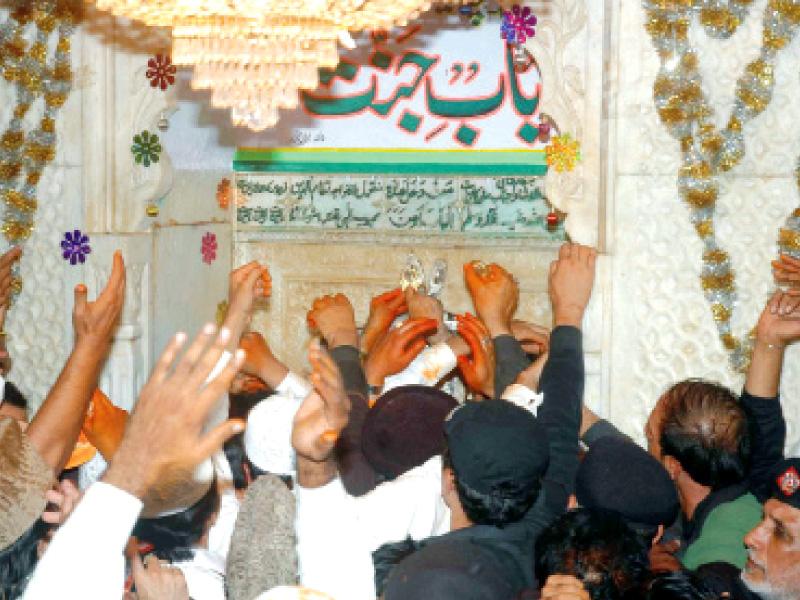 Devotees wait as the shrine caretaker opens the bahishti darwaza on the night of the 6th of Muharram. PHOTO: EXPRESS