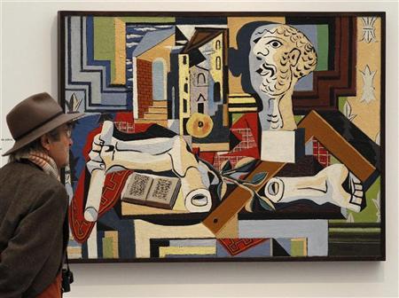 A man stands in front of a painting by Pablo Picasso. PHOTO: REUTERS