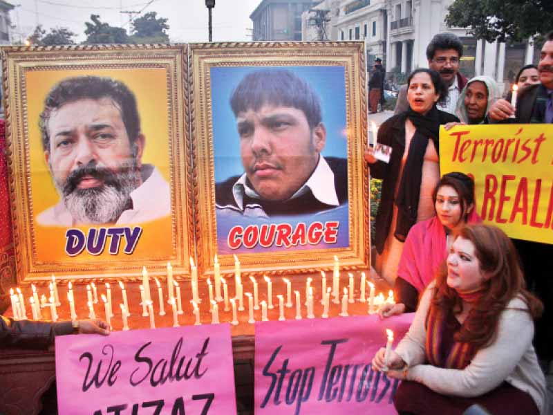 Civil society members light candles in the memory of Aslam and Hasan. PHOTO: ABID NAWAZ
