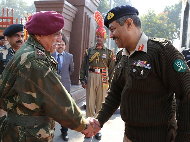 Maj Gen Amir Riaz, DGMO Pakistan Army receiving his counter part, DGMO Indian Army Lt Gen Vinod Bhatia on arrival at Wagha Border in December 2013. PHOTO: ISPR.GOV.PK