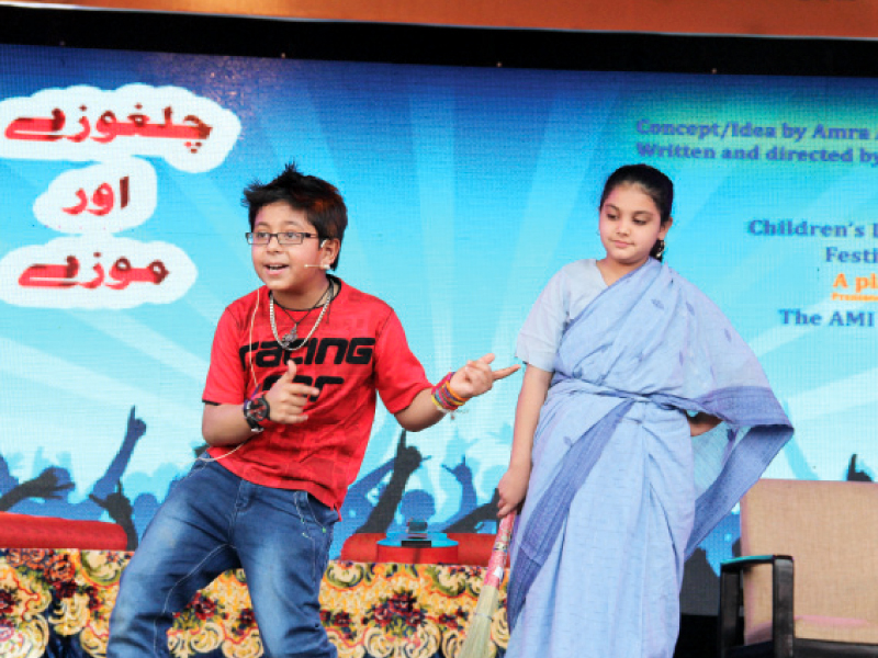 A young boy, acting as Kamil in the play titled Chilghozay aur Mozey, dances while the character of his aunt looks at him. PHOTOS: AYESHA MIR/EXPRESS