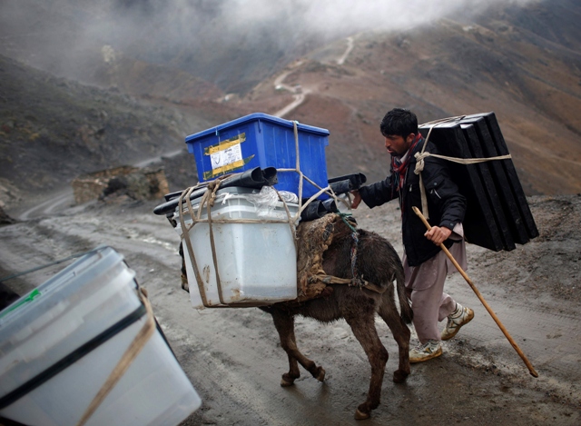 An Afghan man tries to control his donkey loaded with ballot boxes to be transported to polling stations which are not accessible by road in Shutul, Panjshir province, April 4, 2014. Photo: REUTERS