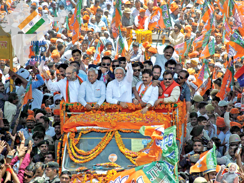 BJP prime ministerial candidate Narendra Modi waves to supporters as he arrives to file his election nomination papers in Varanasi. PHOTO: AFP/FILES