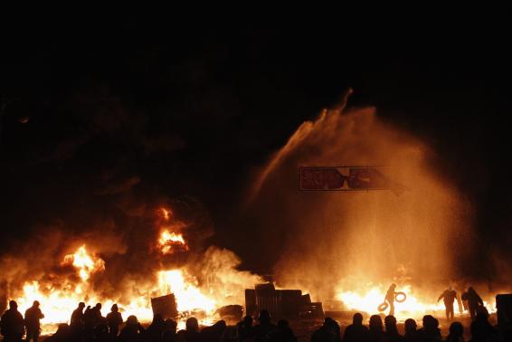 In this file photo, a pro-European protester throws tyres into a fire during street violence in Kiev. PHOTO: REUTERS