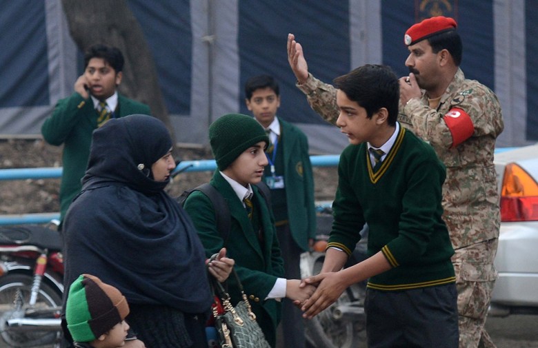 A mother drops her children amid heightened security at the Army Public School in Peshawar on January 12, 2015. PHOTO: AFP