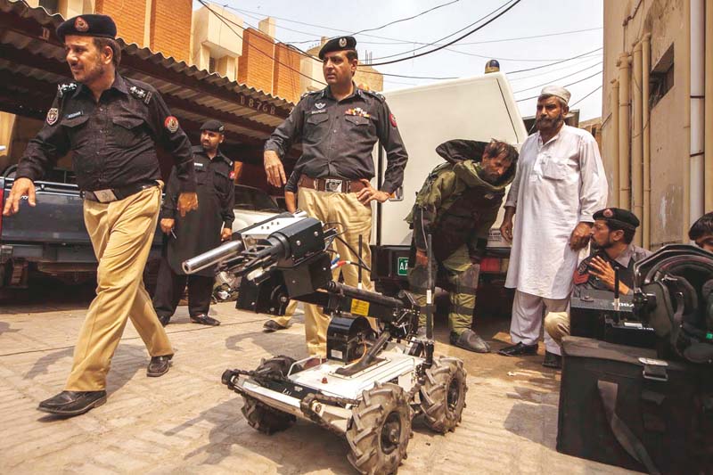 Assistant Inspector General of police Shafqat Malik watches members of the bomb disposal squad display their equipment. PHOTO: REUTERS