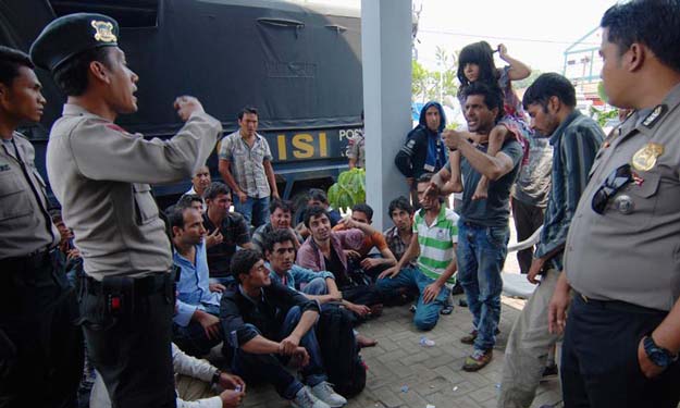 Asylum seekers from Afghanistan and Pakistan argue with Indonesian policemen at a temporary shelter in Merak, Indonesia's Banten province September 27, 2013. &mdash; Photo by Reuters
Asylum seekers from Afghanistan and Pakistan argue with Indonesian policemen at a temporary shelter in Merak, Indonesia's Banten province September 27, 2013. PHOTO: REUTERS