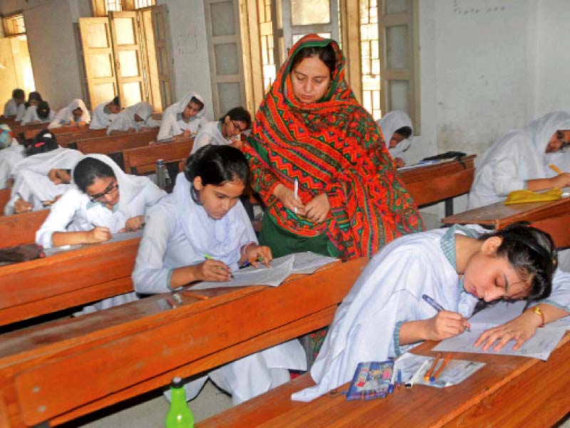 Students appear for Intermediate exams at a centre in Karachi. Numerous candidates have been caught cheating across the province since the exams started this week. PHOTO: FILE