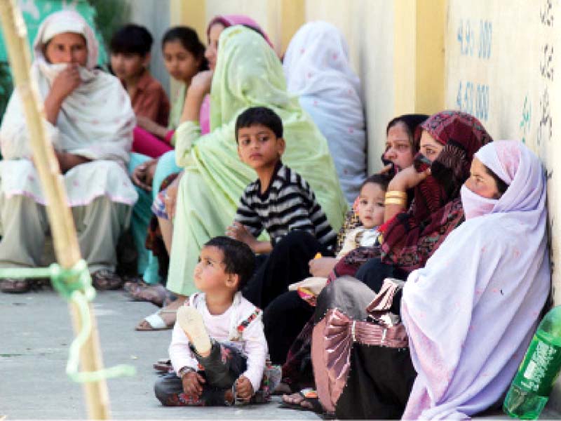 In the absence of seating arrangements at Government High School 4, Abbottabad, voters sit on the floor. PHOTO: ONLINE