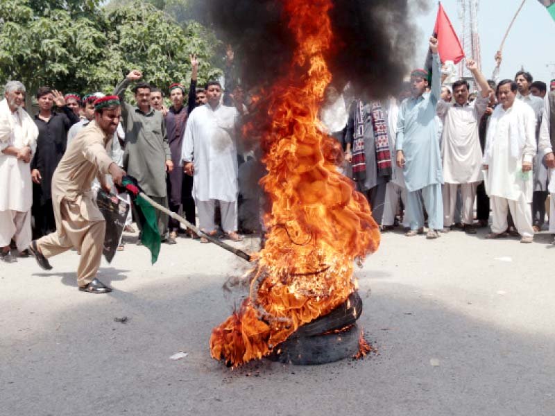 Pakistan Peoples Party workers set fire to tyres outside the Peshawar Press Club. PHOTO: MUHAMMAD IQBAL/EXPRESS