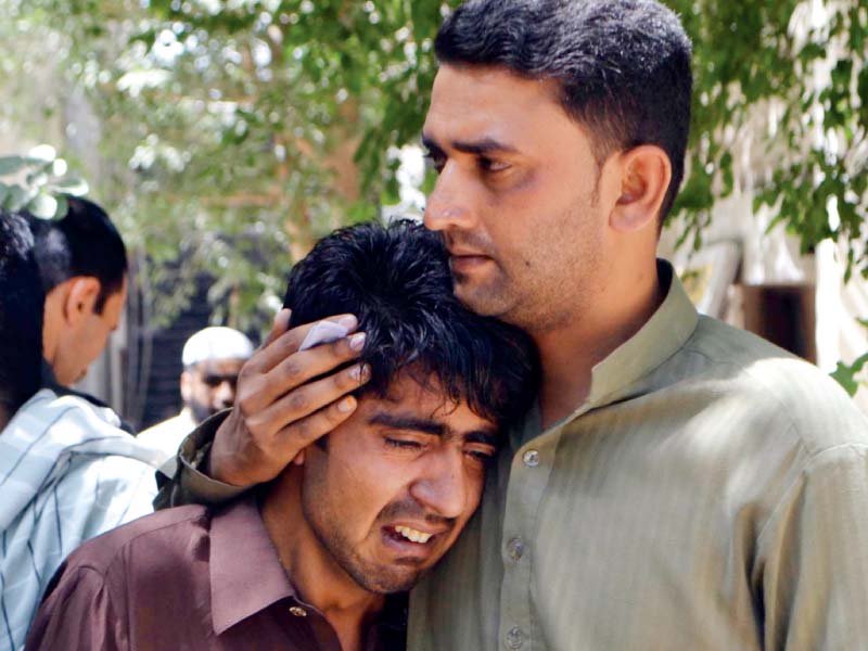 Relatives of a slain policeman mourn his death. PHOTO: INP