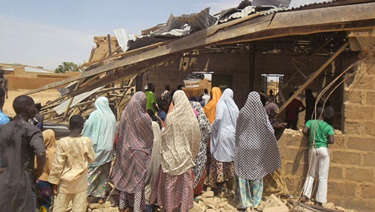 People gather around the Redeemed Christian Church of God, after a bomb blast. PHOTO: AP