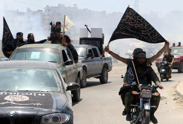 Fighters from al Qaeda's Syrian affiliate Al-Nusra Front drive in the Syrian city of Aleppo flying flags. PHOTO: AFP