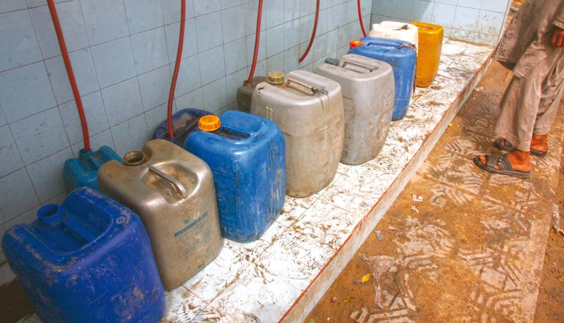 Empty containers are lined up to be filled with water as Lyari faces the worst kind of water crisis it ever witnessed. Residents are left with no option but to visit communal taps to collect the basic commodity for sustenance. PHOTO: ATHAR KHAN/EXPRESS