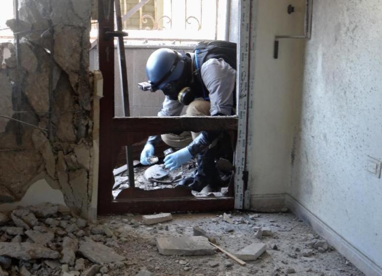 A United Nations weapons expert collects samples during an investigation into a 2013 suspected chemical weapons strike near Damascus. PHOTO: AFP