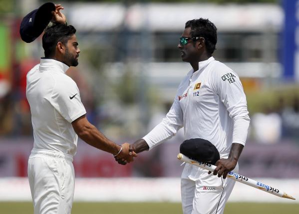 Sri Lanka's captain Mathews (L) shakes hands with India's captain Kohli (R) after Sri Lanka won their first test cricket match against India in Galle. PHOT: REUTERS