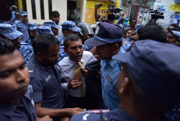 Maldives police try to move former president Mohamed Nasheed (C) during a scuffle as he arrives at a courthouse in Male on February 23, 2015. PHOTO: AFP