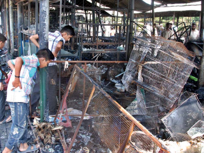 Passers by inspect the debris at the site.  PHOTO: RIAZ AHMED/EXPRESS