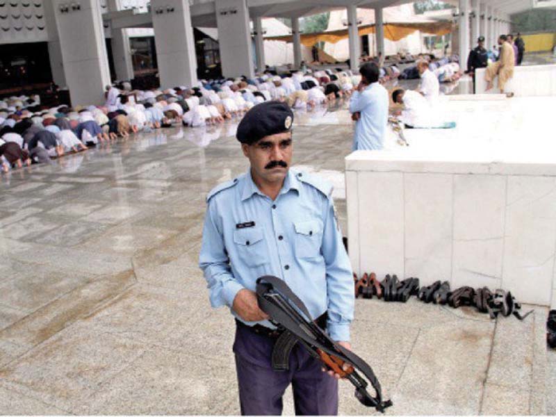 Police official stands alert during Eid prayers. PHOTO: FILE