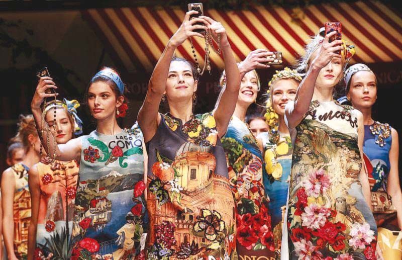 Models take selfies during the parade at the end of the Dolce & Gabbana Spring/Summer 2016 collection. PHOTO: REUTERS