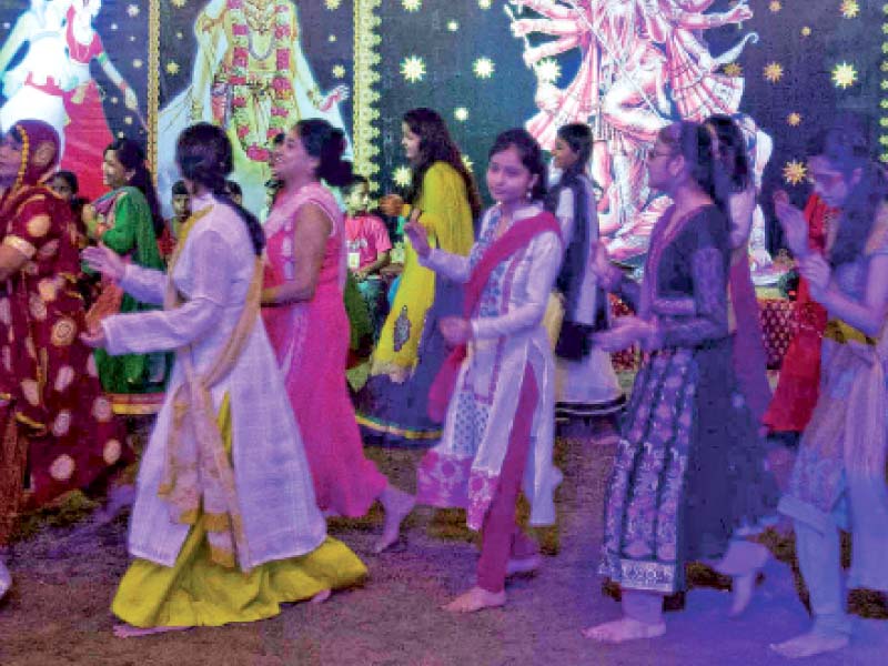 Members of the Hindu community partake in the traditional ‘dandiya’ dance on the eve of dussehra, which marks the end of Navratri, at the Swami Narayan Mandir on Tuesday night. PHOTO: ATHAR KHAN/EXPRESS