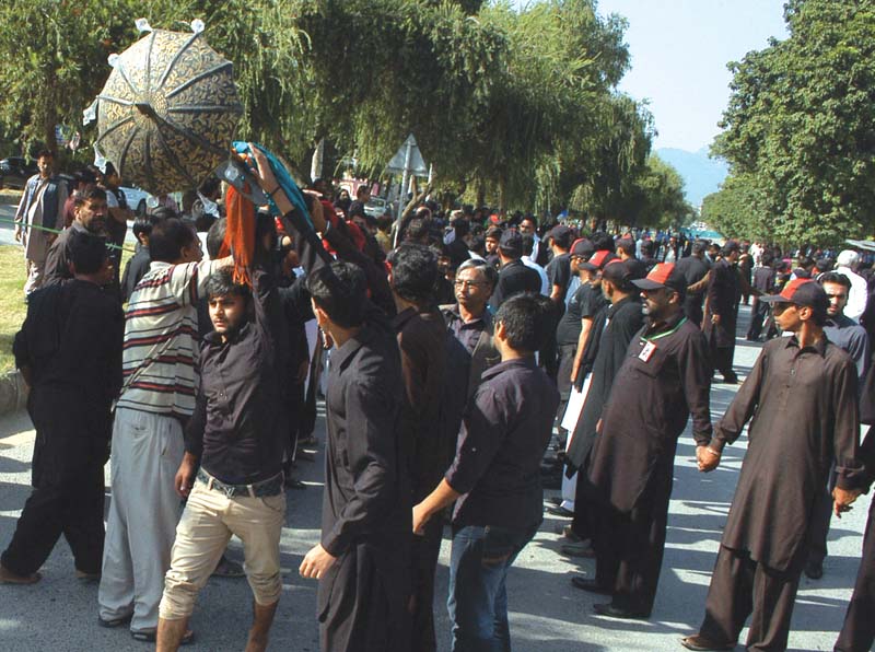 Bomb disposal squad personnel check the route for explosives (left) while the procession marches through Islamabad. PHOTOS: WASEEM NAZIR/EXPRESS