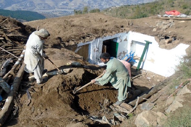 People rebuilding their houses, after the recent earthquake. PHOTO: INP