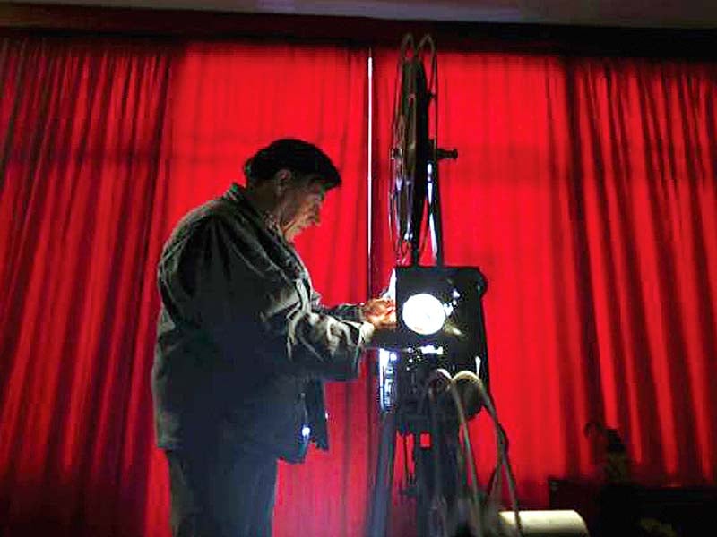 Feliciano checks his projector before showing a film in Monforte, Portugal on May 16, 2015. PHOTO: REUTERS