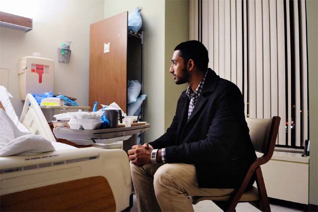 Wasiullah Mohamed, executive director of the Islamic Center of Pittsburgh, sits Friday with a taxi driver who was shot by a passenger last week. The victim, who asked not to be identified, said he was shot in the back for being Muslim. PHOTO: POST-GAZETTE