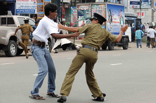 Sri Lankan police officer beating a protester on October 29, 2015. PHOTO: AFP