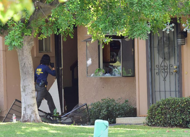 A member of an FBI evidence response team enters the home of San Bernardino shooters Syed Farook and Tashfeen Malik in Redlands, California on December 3, 2015 PHOTO: AFP