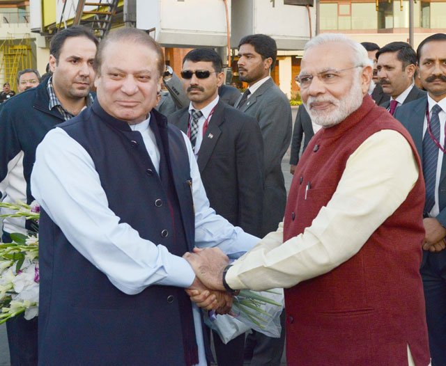 PM Nawaz Sharif shakes hands with his Indian counterpart Narendra Modi upon latter's arrival at the Allama Iqbal International Airport in Lahore on December 25, 2015. PHOTO: PID