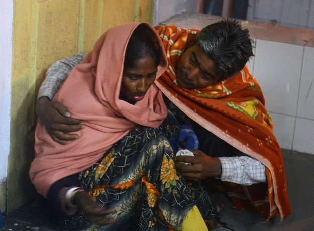 An injured Indian woman is comforted by her husband as she waits for treatment at Siliguri Hospital following an earthquake in Siliguri on January 4, 2016.  PHOTO: AFP