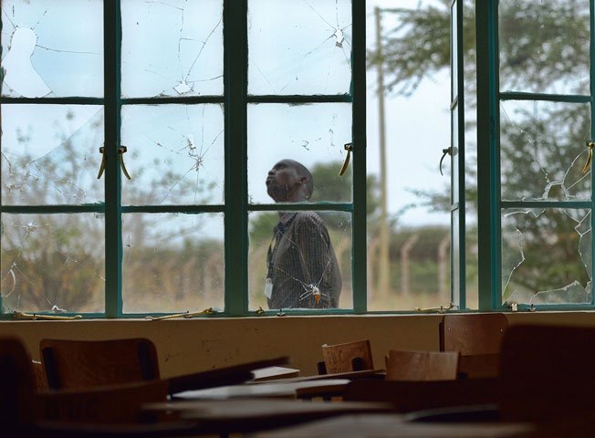 A man walks outside a lecture hall with bullet-shattered window panes in Garissa university on January 11, 2016. PHOTO: AFP