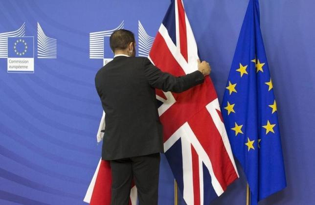 An employee at the European Commission adjusts a British flag ahead of the meeting between Prime Minister David Cameron and European Commission President Jean-Claude Juncker in Brussels, October 15, 2015. PHOTO: REUTERS