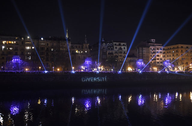 People line the river banks during a performance dubbed "Bridge of Cohabitation" created by the artist Hansel Cereza in the northern Spanish Basque city of San Sebastian on January 23, 2016. PHOTO: AFP