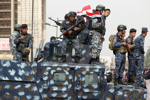 Iraqi security forces stand guard during a protest on March 25, 2016, outside the main gates of Baghdad's Green Zone. PHOTO: AFP